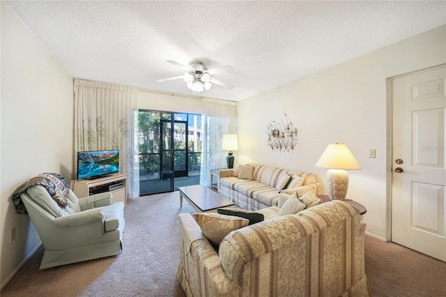 carpeted living room featuring ceiling fan and a textured ceiling