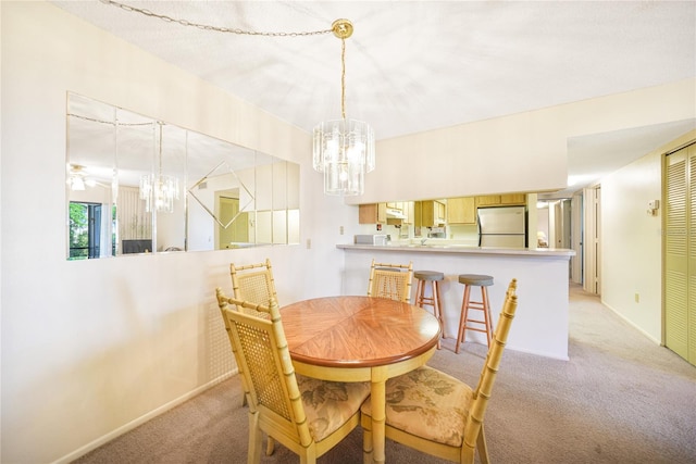 dining area featuring light carpet and ceiling fan with notable chandelier