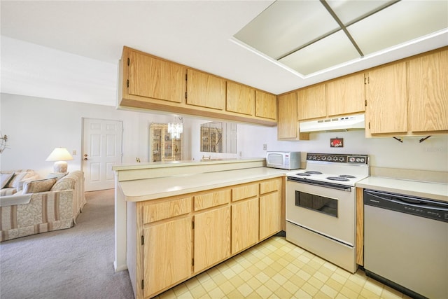 kitchen featuring white appliances, light colored carpet, kitchen peninsula, and a notable chandelier