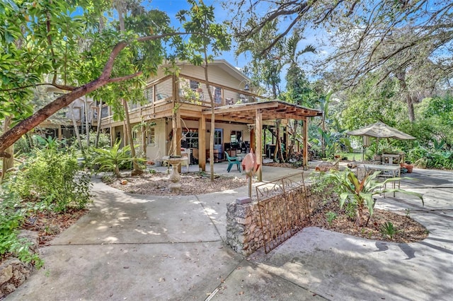 rear view of house featuring a patio and a deck