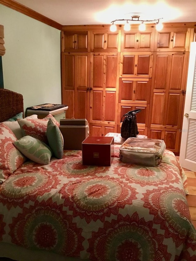 bedroom with hardwood / wood-style flooring and crown molding