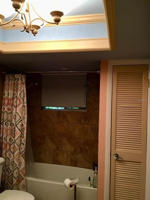 bathroom featuring toilet, an inviting chandelier, and shower / bathtub combination with curtain