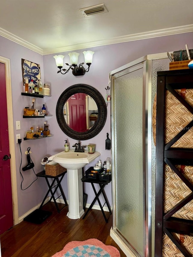 bathroom with crown molding, wood-type flooring, and walk in shower