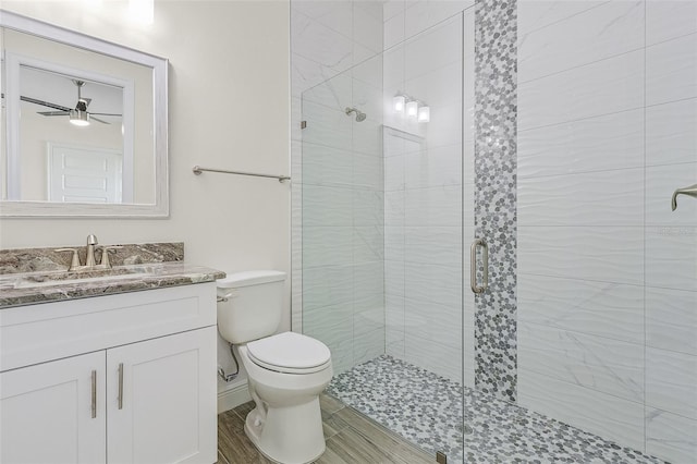 bathroom featuring walk in shower, ceiling fan, toilet, and large vanity