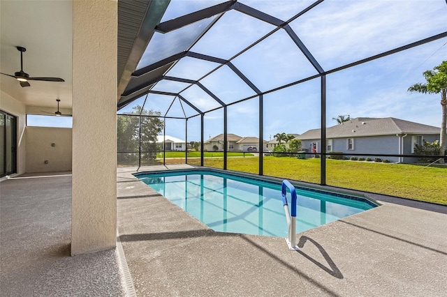 view of swimming pool with a patio, a yard, ceiling fan, and glass enclosure