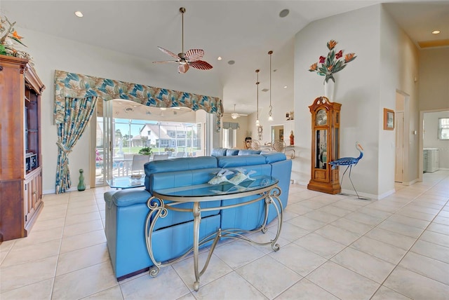 tiled living room with ceiling fan and high vaulted ceiling