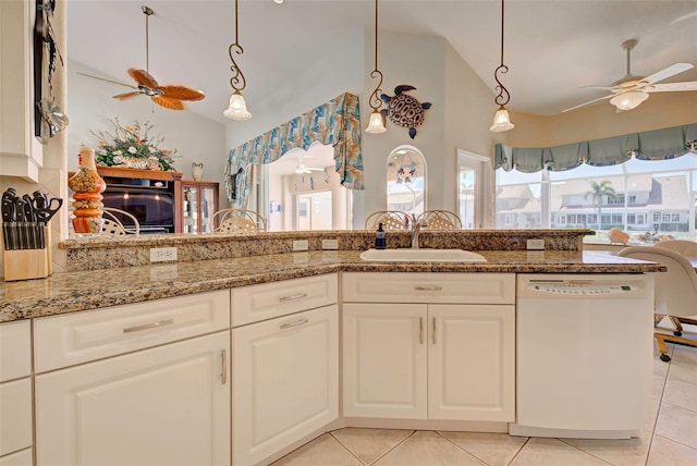 kitchen with light stone countertops, sink, light tile patterned floors, white dishwasher, and white cabinets