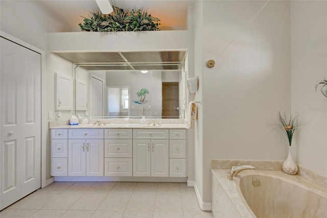 bathroom with tiled bath, tile patterned flooring, and vanity