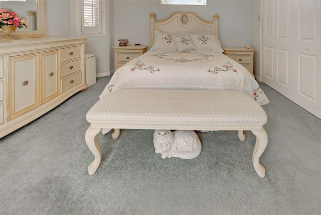 bedroom featuring light colored carpet and a closet