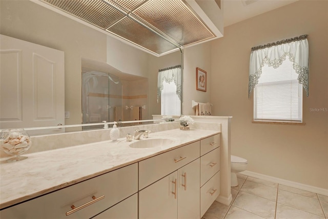 bathroom with tile patterned floors, vanity, a healthy amount of sunlight, and toilet