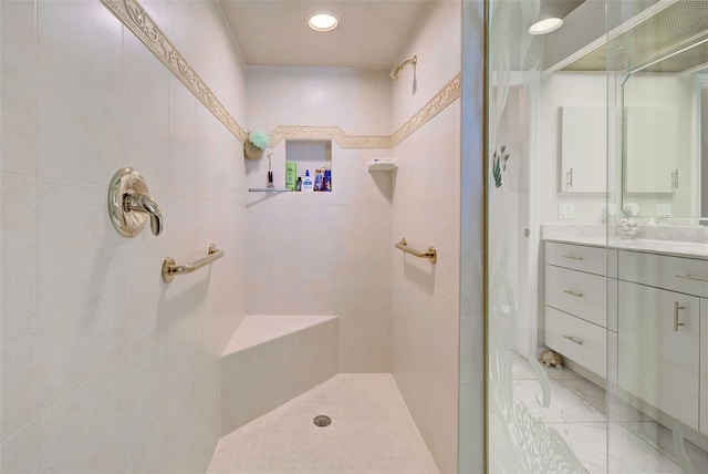 bathroom featuring a tile shower and vanity