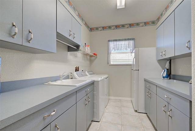 laundry area with washer and clothes dryer, sink, and light tile patterned flooring