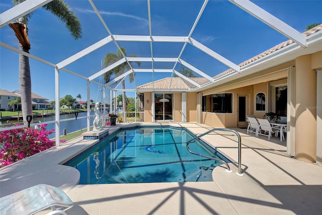 view of pool featuring a lanai, a patio area, and a water view