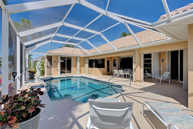 view of pool featuring glass enclosure and a patio area