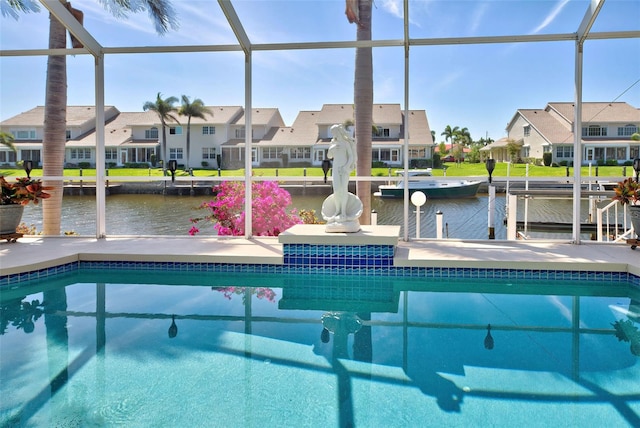 view of pool featuring glass enclosure, a water view, and a boat dock