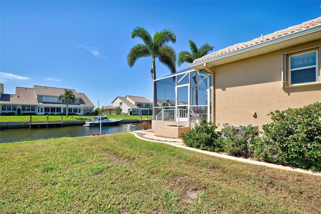 view of yard with a water view and a lanai