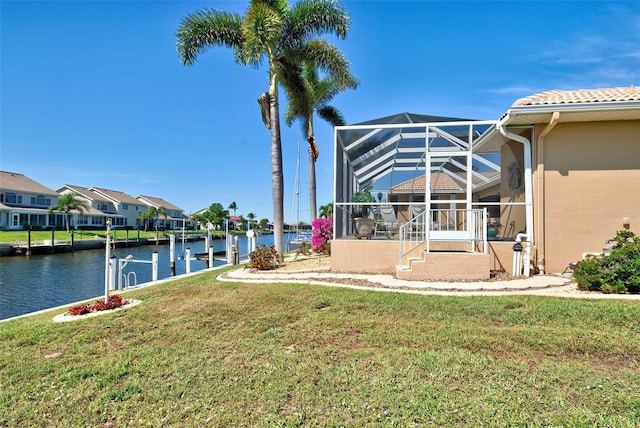 view of yard featuring a boat dock, a water view, and a lanai