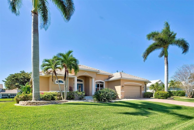 mediterranean / spanish home featuring a garage and a front lawn