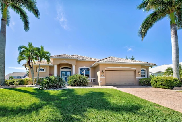 mediterranean / spanish-style home with french doors, a front lawn, and a garage