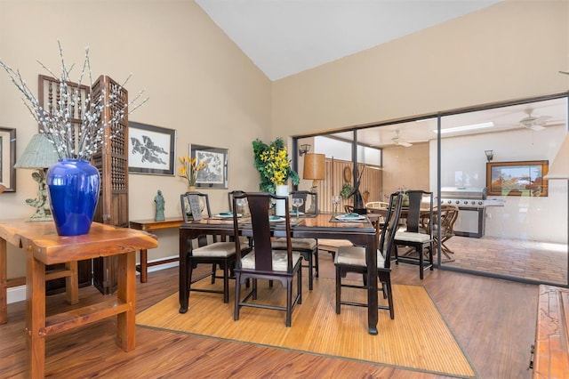 dining area featuring light hardwood / wood-style flooring, ceiling fan, and high vaulted ceiling