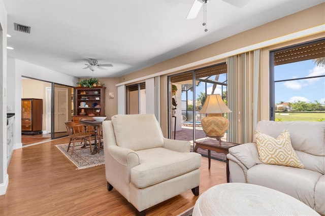 living room with ceiling fan and light wood-type flooring