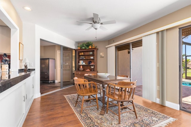 dining space featuring dark wood-type flooring and ceiling fan