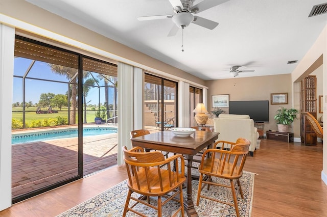 dining area with light hardwood / wood-style floors and ceiling fan