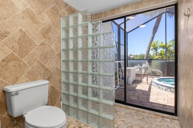 bathroom featuring tile walls, tile floors, and toilet