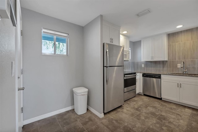 kitchen with visible vents, white cabinets, stainless steel appliances, and a sink