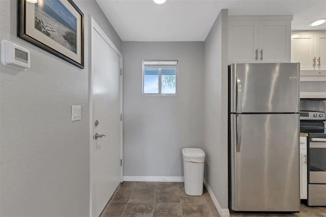 kitchen featuring tile patterned flooring, stainless steel appliances, and white cabinets