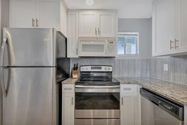 kitchen with white cabinetry, decorative backsplash, and stainless steel appliances