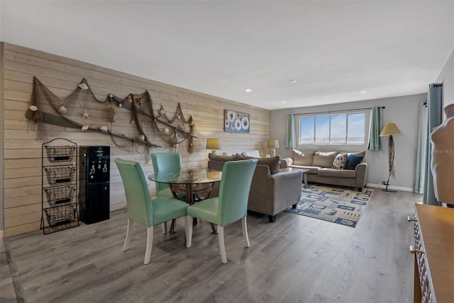 dining room with hardwood / wood-style flooring and wooden walls