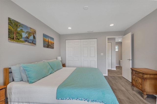 bedroom with recessed lighting, wood finished floors, a closet, and baseboards