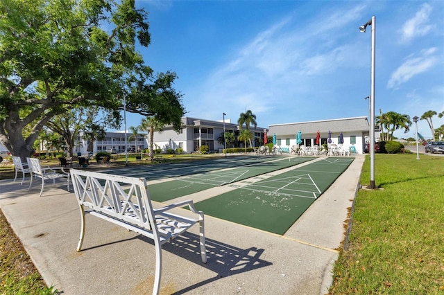 surrounding community featuring shuffleboard and a yard