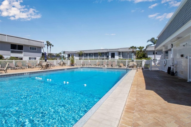 pool featuring a residential view, a patio, and fence