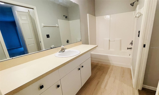 bathroom featuring shower / washtub combination, vanity with extensive cabinet space, and hardwood / wood-style floors