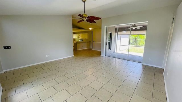 unfurnished living room with vaulted ceiling, ceiling fan, and light tile floors