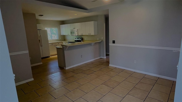 kitchen featuring white appliances, light tile flooring, and white cabinetry