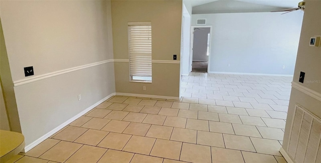 spare room with ceiling fan and light tile floors