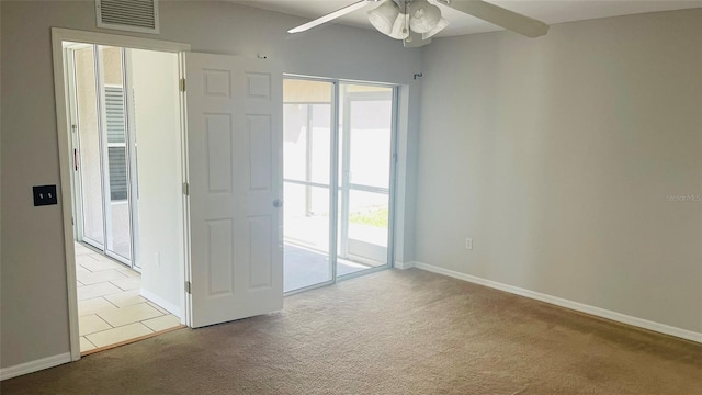 spare room with ceiling fan and light colored carpet