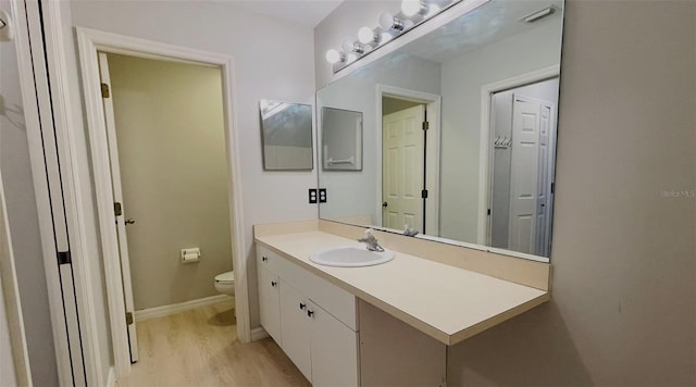 bathroom featuring vanity, toilet, and hardwood / wood-style flooring