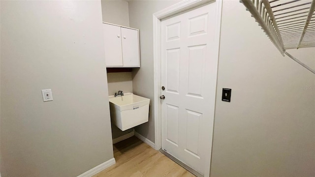 laundry room featuring light hardwood / wood-style flooring and sink