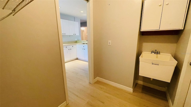 hallway featuring sink and light wood-type flooring