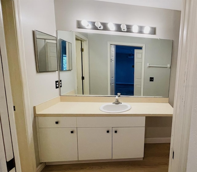 bathroom with oversized vanity and hardwood / wood-style flooring