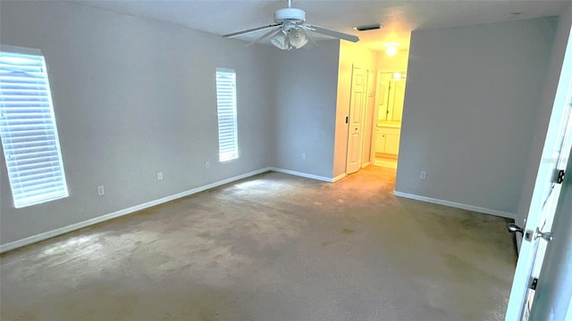 spare room featuring light colored carpet and ceiling fan