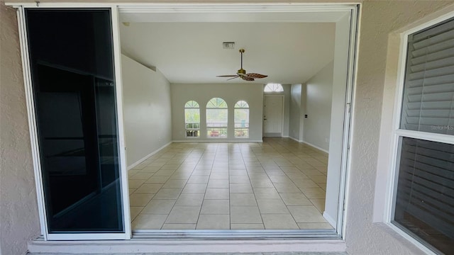 spare room featuring light tile floors and ceiling fan