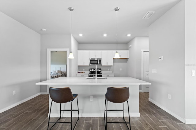 kitchen with white cabinetry, sink, a spacious island, and appliances with stainless steel finishes