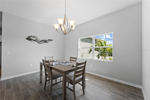 dining space with dark wood-type flooring and an inviting chandelier