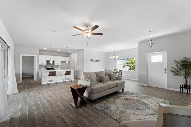 living room featuring ceiling fan with notable chandelier