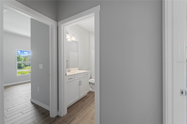 bathroom with a notable chandelier, vanity, and toilet